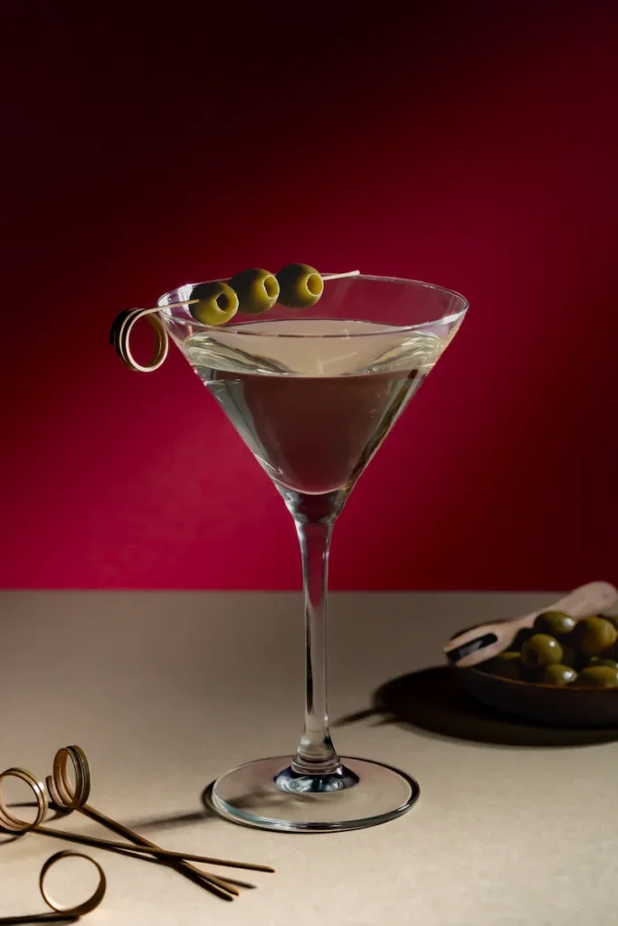 Drink Fotografie eines Martinis in eleganter Kulisse mit Lichtinszenierung vor rotem Hintergrund – Studio Visionelle