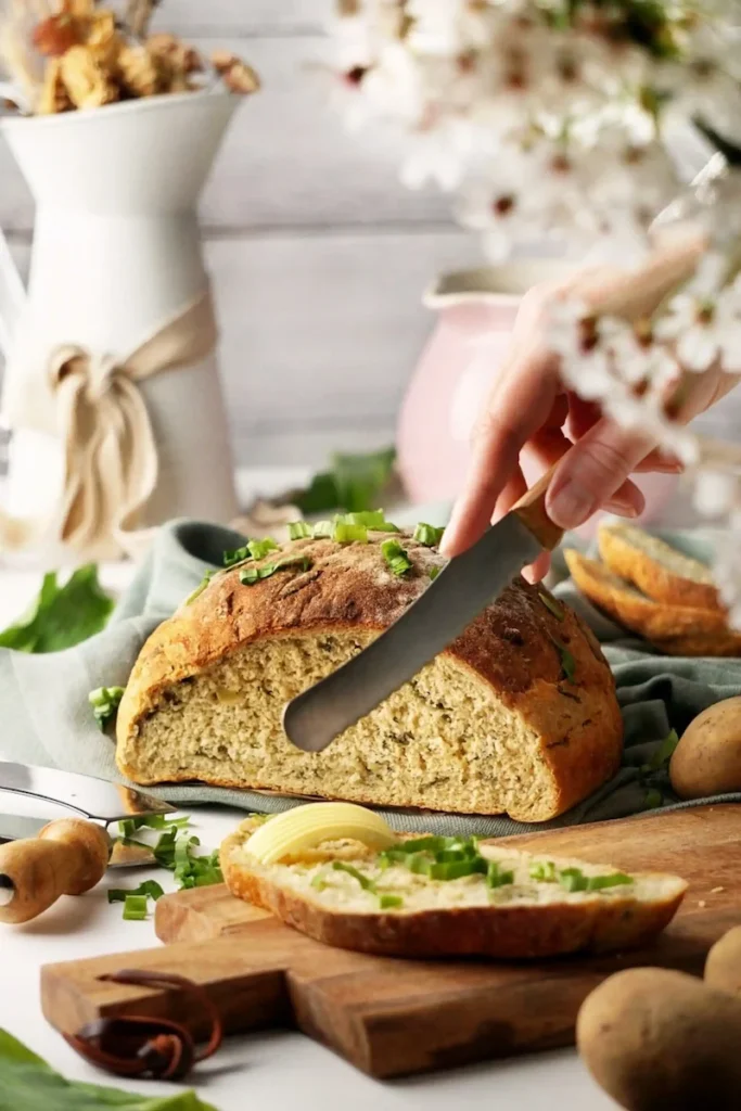 Aufgeschnittenes Kartoffel-Bärlauch-Brot in hellem Landhausstil, natürlich inszeniert und fotografiert von Studio Visionelle.